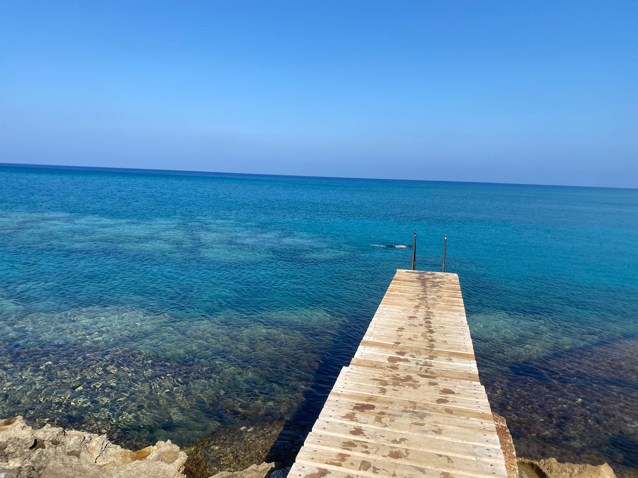 Peaceful November seascape in Protaras, Cyprus, with a long wooden pier and crystal-clear water