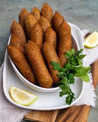 Traditionelle zypriotische Koupes aus Bulgur, goldbraun frittiert und mit Zitrone serviert